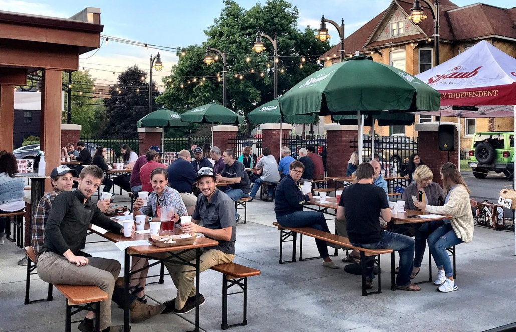 Group of people sitting at picnic tables outside Tap Room