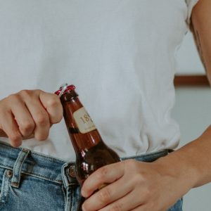 woman opening beer bottle with Straub bottle opener