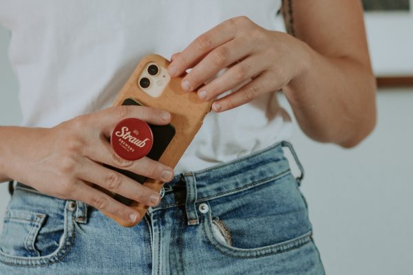 woman holding phone with Straub popsocket on it